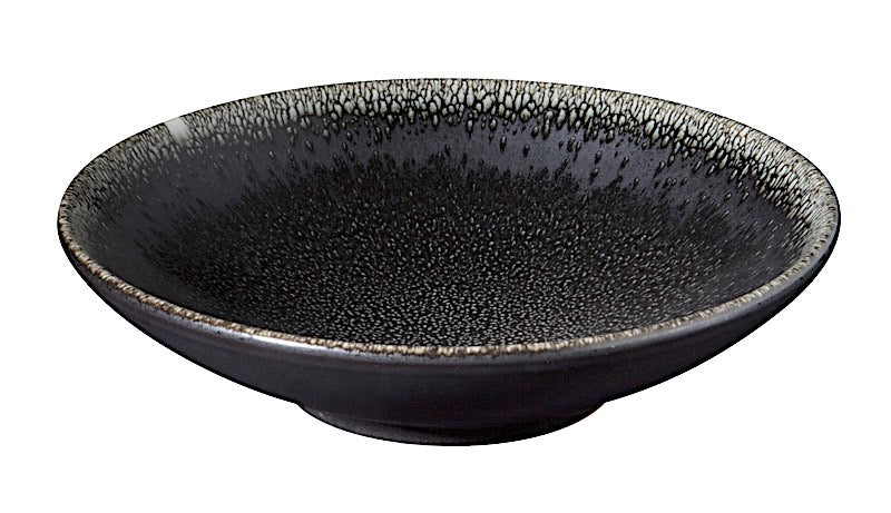 The Tourron Dinnerware Celeste by Jars - Rosenthal is a shallow, round black ceramic bowl with a speckled textured interior and a subtly flared rim, exemplifying artisanal craftsmanship against a white background.