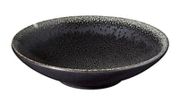 The Tourron Dinnerware Celeste by Jars - Rosenthal is a shallow, round black ceramic bowl with a speckled textured interior and a subtly flared rim, exemplifying artisanal craftsmanship against a white background.