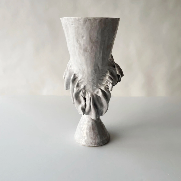 The Without Her Trumpet Vase by Ellen Robinson Studio is a hand-formed ceramic piece with a matte white glaze, featuring organic, leaf-like forms around the middle, a flared top, and conical base. Shown against a light gray background.