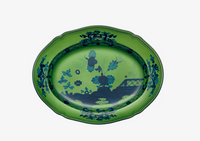 The Oriente Italiano Dinnerware Malachite oval platter by Ginori 1735 features a blue floral and bridge motif on white, with scalloped edges—a striking piece of Italian tableware.
