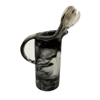 The Nashi Home Swirl Resin Classic Pitcher in black and white, paired with matching marbled serving fork and spoon, is shatterproof and dishwasher safe. Set against a plain white background, it’s perfect for easy cleanup.