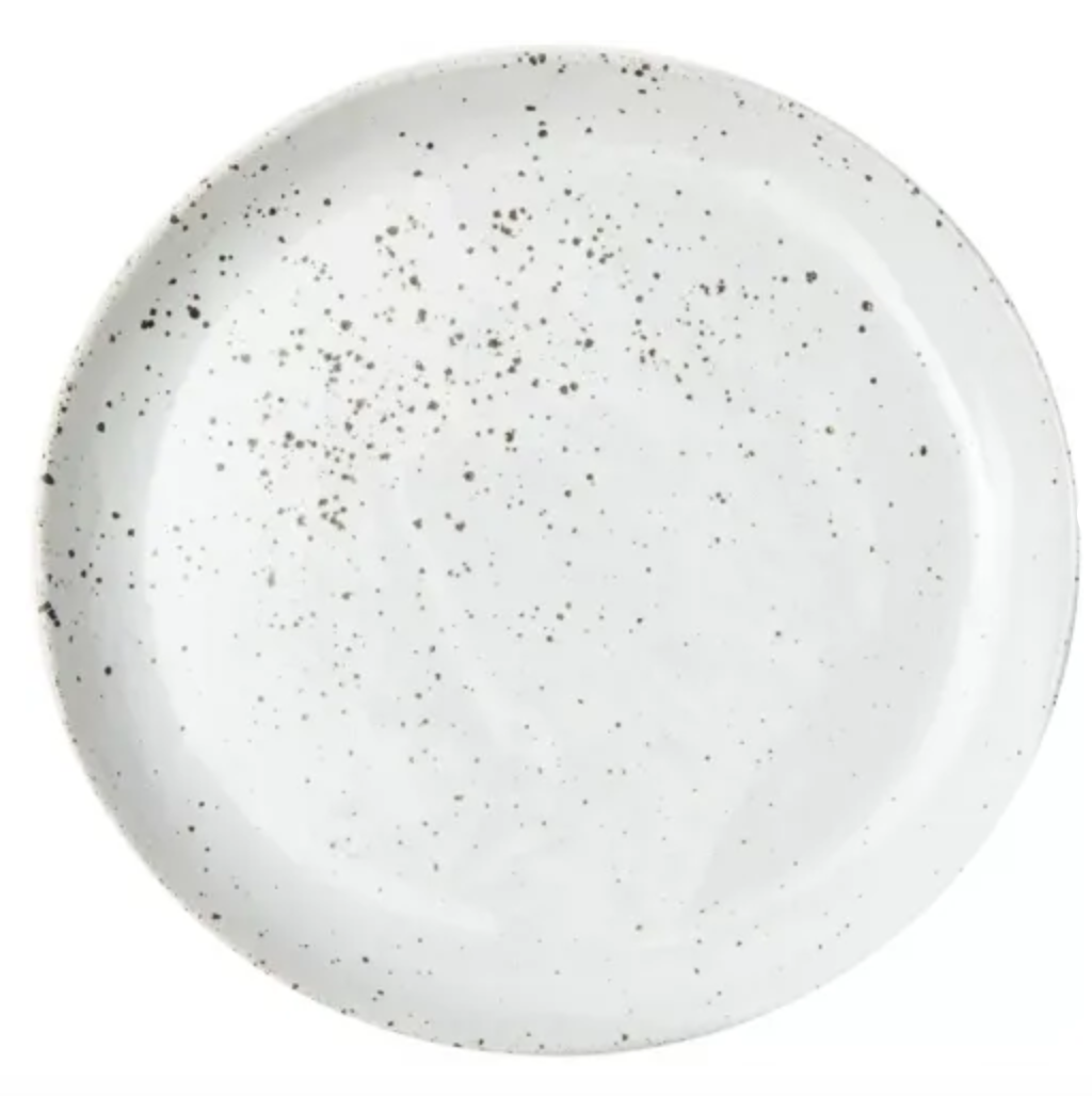 This handcrafted round white ceramic plate features an uneven pattern of black speckles and is part of the Marcus Dinnerware - White Salt Glaze - Set of 4- by Blue Pheasant.