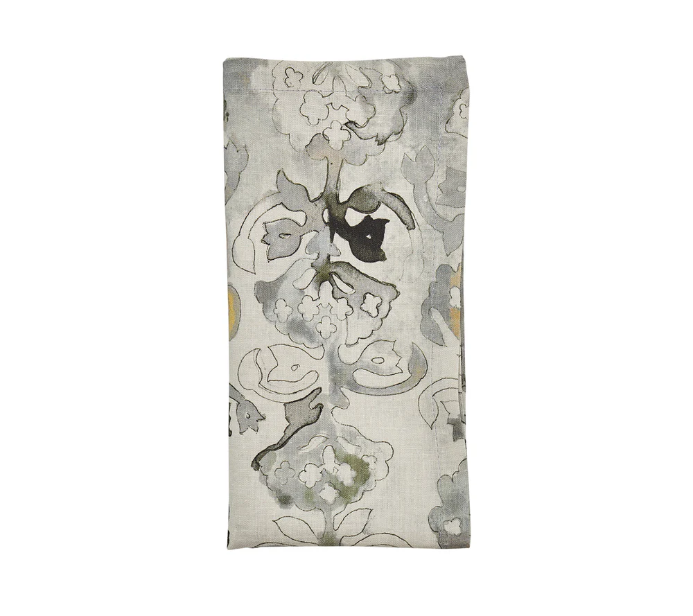 The Kim Seybert Giverny Napkin Set of 4 features rectangular, folded napkins with a gray, black, and muted yellow floral pattern on a light beige background inspired by Monet.