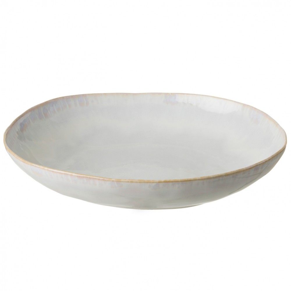 The Brisa Sal Dinnerware plate by Casafina/Costa Nova features a shallow, round stoneware design with a lightly uneven rim and glossy off-white finish, inspired by the Algarve coast.