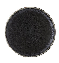 The Tourron Dinnerware Celeste plate by Jars - Rosenthal features a round, black glazed stoneware design with a textured surface and a gradient from dark center to lighter, speckled edges.