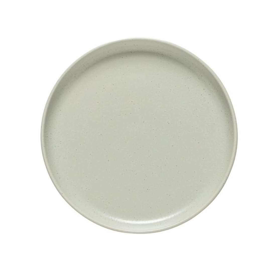 The Costa Nova Pacifica Dinnerware Oyster Grey plate is a plain, round, light gray ceramic dish with a slightly raised rim, elegantly displayed from above against a white background.