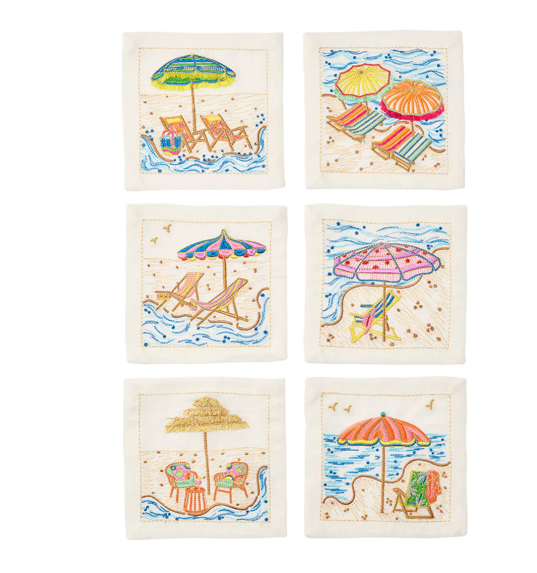 The Kim Seybert Cocktail Napkin Set of 4 - Sunny Isles features embroidered fabric napkins with vibrant beach scenes, umbrellas, and accessories—ideal as hostess gifts or for any coastal gathering.