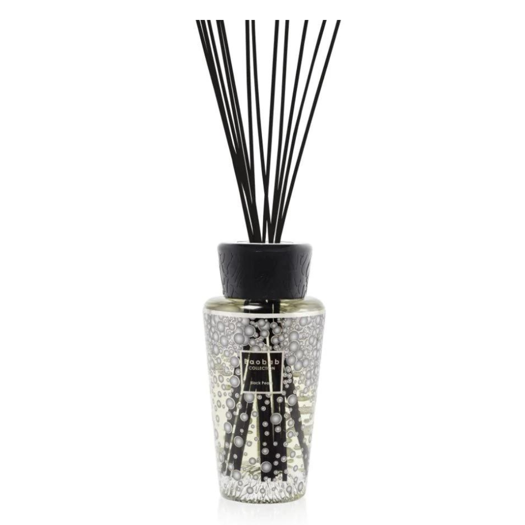 The Baobab Pearls Diffuser features a clear glass bottle with small raised dots, black reeds, a black cap, and a front label. Filled with fragrance liquid, it blends elegance and luxury for any space.