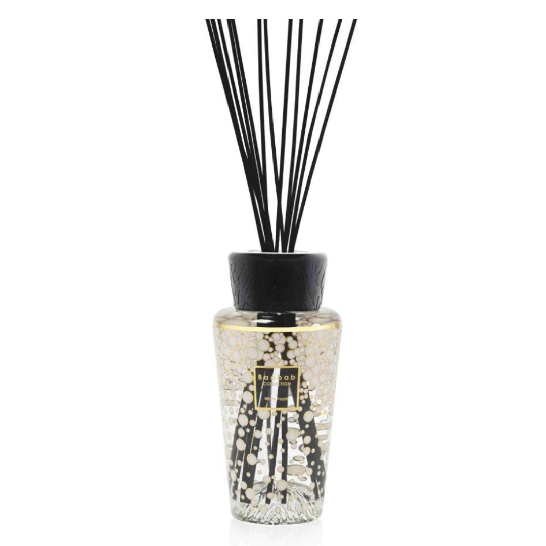 The Baobab Pearls Diffuser is a luxury fragrance piece with a black cap, slim black reeds, and light-colored liquid. Its textured glass features gold and white accents, providing elegant decor and scent for any space.