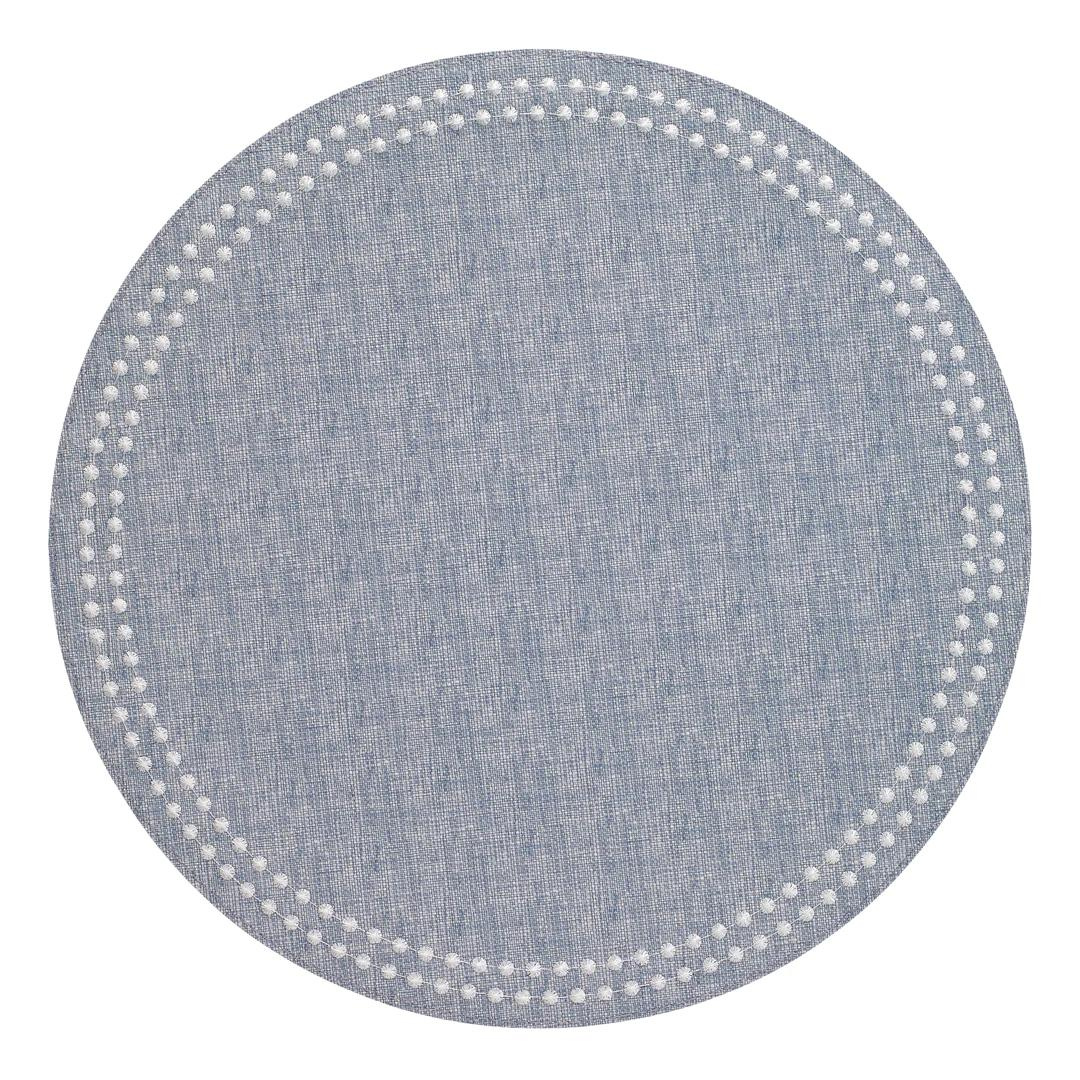 The Bodrum Pearls Round Placemat Set of 4 in light blue features a subtle textured design and a border of small white dots, adding modern charm to any table—perfect for an elegant, embroidered placemat style.