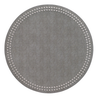 The Bodrum Pearls Round Placemat Set of 4 in gray is made from phthalate-free vinyl and features a subtle fabric texture with small white dots forming two concentric circles near the edge.