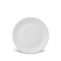 A white charger plate from the Perlée White Dinnerware collection by L'Objet, crafted in Limoges porcelain with a beaded border, is shown against a white background.