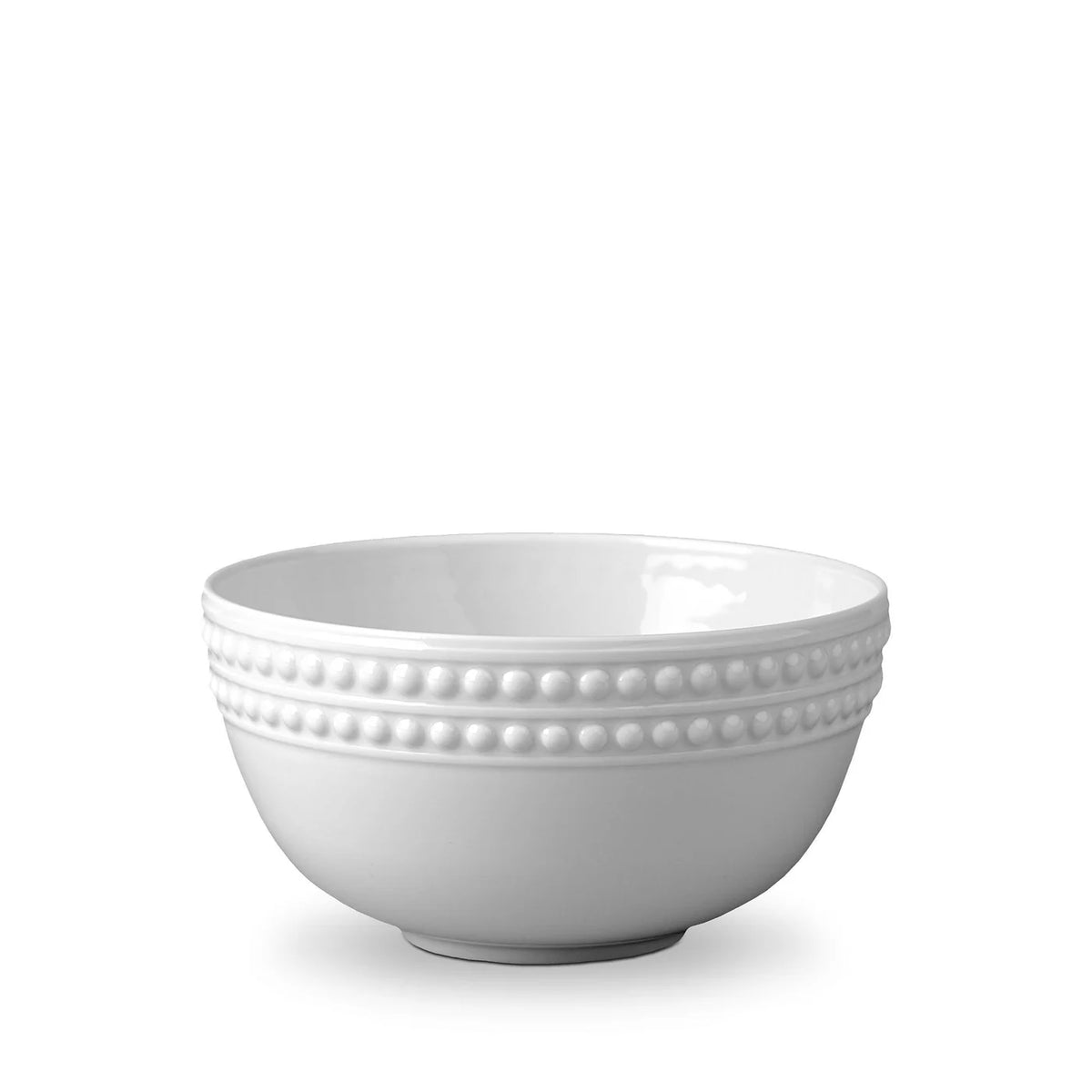 The Perlèe White Dinnerware by L'Objet features a smooth white ceramic bowl with a decorative raised dot pattern around the rim, inspired by the Limoges Porcelain Perlèe White Collection, shown on a plain white background.