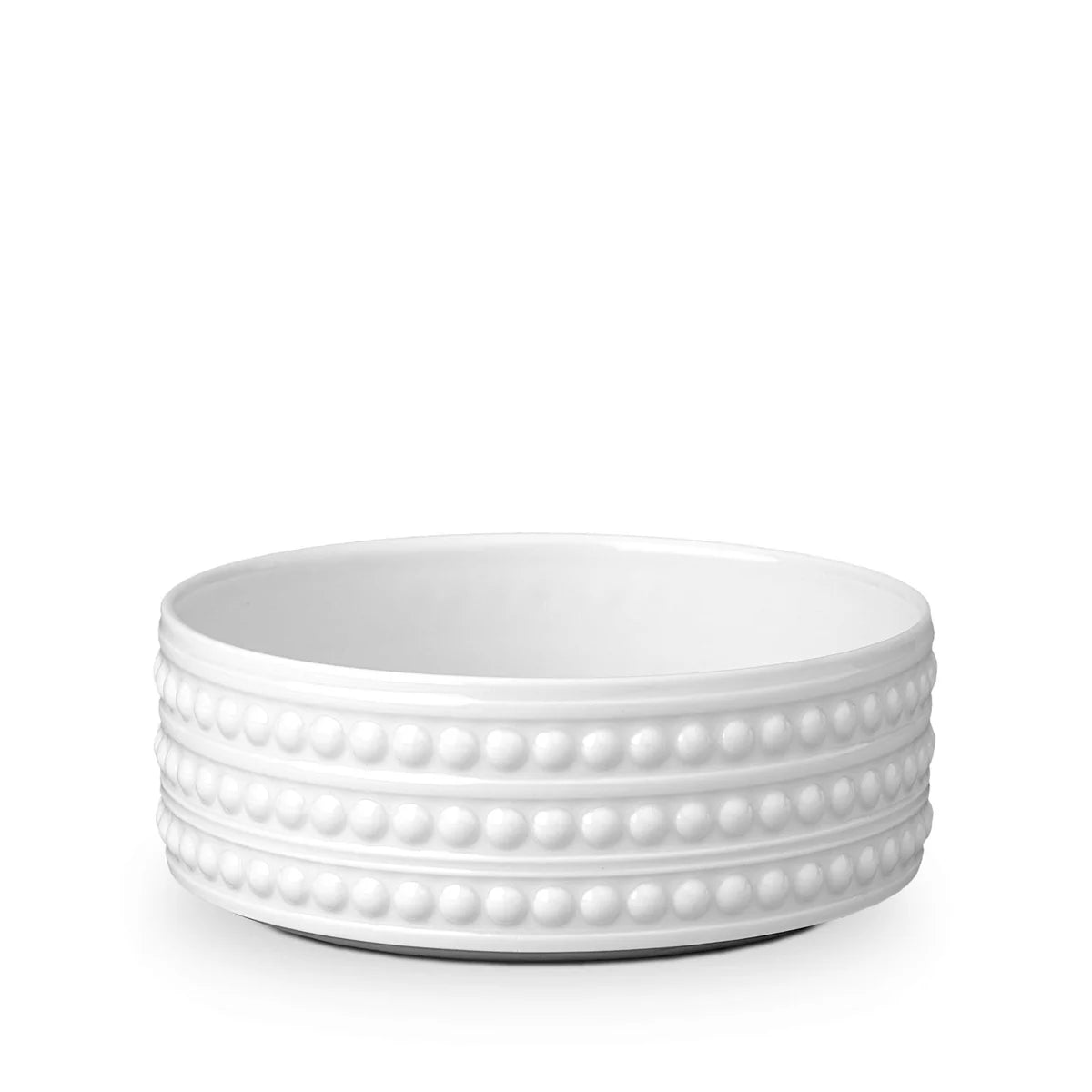 The L'Objet Perlèe White Dinnerware features a round, white Limoges Porcelain bowl adorned with three rows of raised, evenly spaced dots on its exterior, displayed against a clean white background.