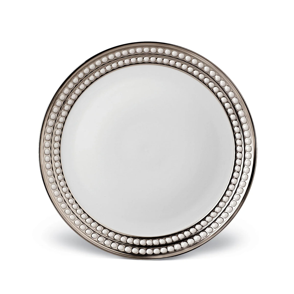 The L'Objet Perlée Platinum Dinnerware is a round white porcelain plate with a platinum rim and two rows of raised beaded detailing, offering an elegant and decorative design.