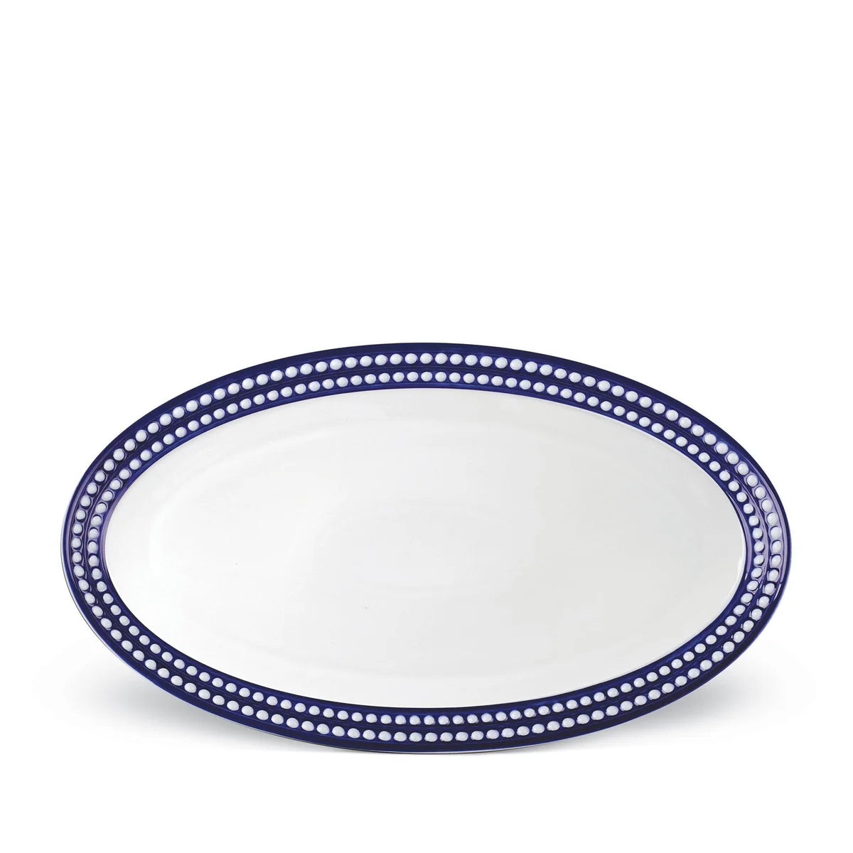 The Perlèe Blue Dinnerware platter by L’Objet features an oval white ceramic design with a dark blue border adorned with white dots, making it perfect for enhancing your blue and white table settings.