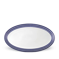 The Perlèe Blue Dinnerware platter by L’Objet features an oval white ceramic design with a dark blue border adorned with white dots, making it perfect for enhancing your blue and white table settings.