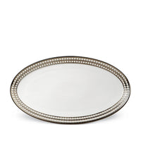 An oval white Perlée Platinum Dinnerware platter by L’Objet, featuring a raised beaded border and platinum rim, is shown from above on a plain white background.