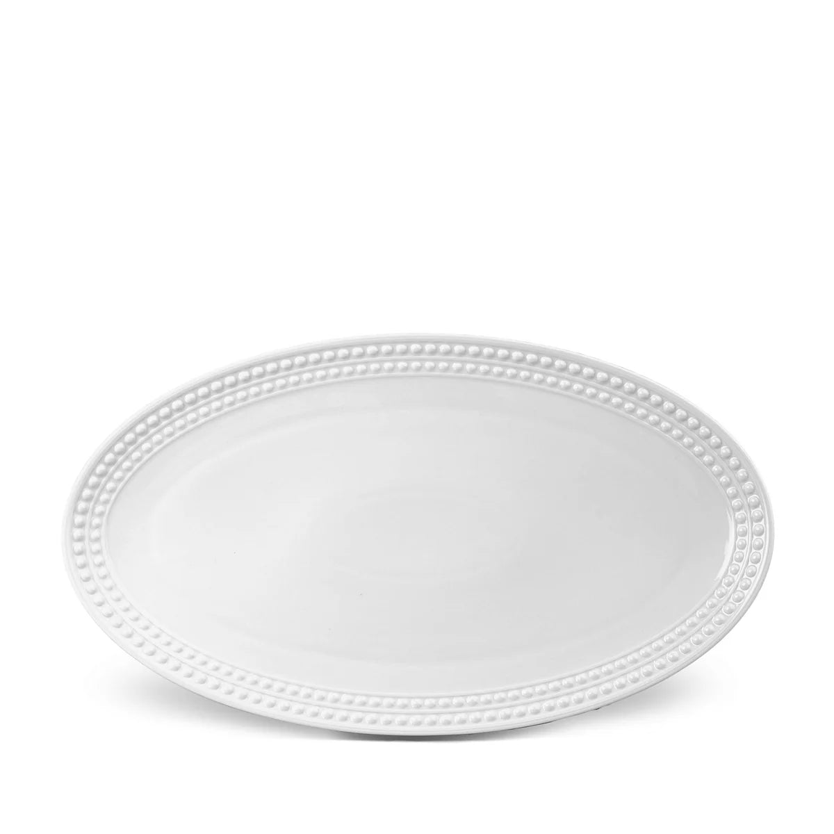 The Perlèe White Dinnerware by L'Objet is a white oval Limoges porcelain plate featuring a raised beaded border, shown on a white background.