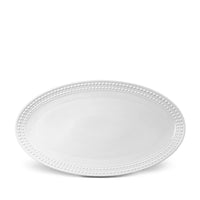 The Perlèe White Dinnerware by L'Objet is a white oval Limoges porcelain plate featuring a raised beaded border, shown on a white background.