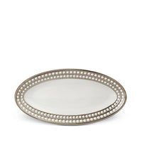 The L'Objet Perlée Platinum Dinnerware features an oval-shaped white porcelain serving platter with raised beaded detailing and a shimmering platinum rim.