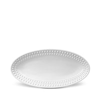 The Perlèe White Dinnerware serving platter by L'Objet features an oval, white ceramic design with a raised beaded pattern along the rim, inspired by the Perlée White Collection.