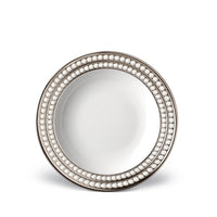 The L'Objet Perlée Platinum Dinnerware plate is round, white porcelain with a platinum rim and three rows of raised white beads on the border. Its glossy center completes the elegant design.