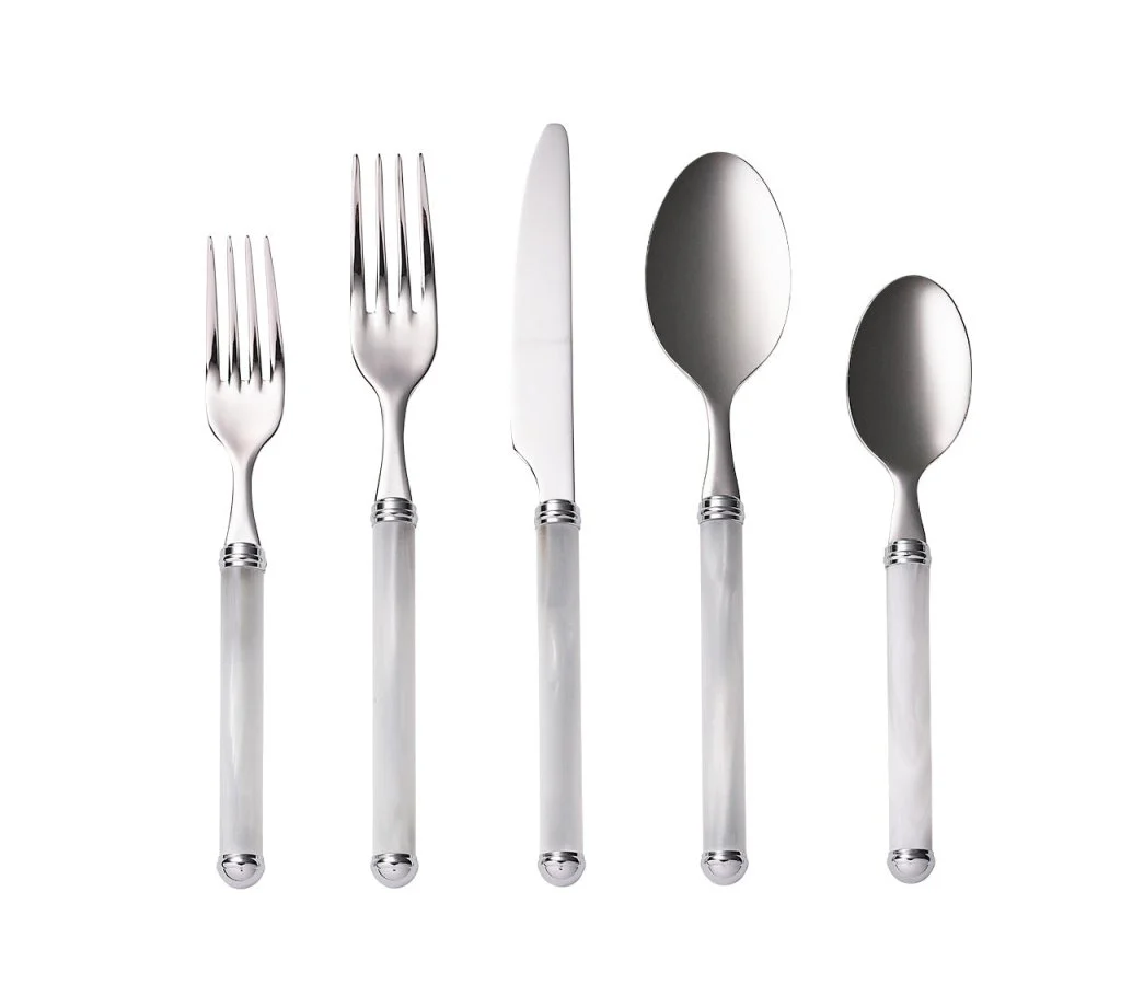 The Kim Seybert Mirage Flatware 5 pc Place Set in White/Silver features shiny metallic heads and white handles, is made in Italy, dishwasher safe, and displayed side by side on a white background.