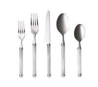 The Kim Seybert Mirage Flatware 5 pc Place Set in White/Silver features shiny metallic heads and white handles, is made in Italy, dishwasher safe, and displayed side by side on a white background.