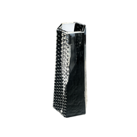 The BB Faceted Mini Vase by Matt Kolbrener is a tall, black, handblown glass piece with a hexagonal silhouette and textured pattern on one side—a true handmade art object.