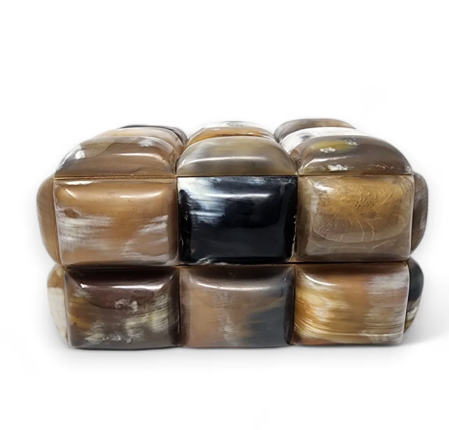Add a playful touch to your space with the Bubble Horn Box by A Sanoma Inc—a rectangular box adorned with twelve glossy, marble-patterned squares in earthy tones, arranged in two rows against a crisp white background.
