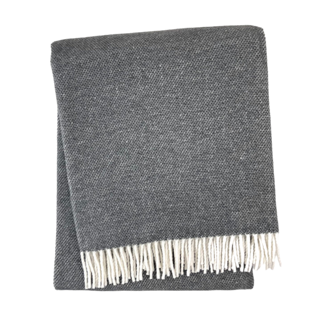 The A Soft Idea Pixel Throw in dark gray features a white fringe on one edge and is displayed folded on a white background. This stylish throw is machine washable for easy care.