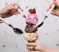 Four hands use Kim Seybert's Mirage Flatware 5 pc Place Set in White/Silver to scoop strawberry, chocolate chunk, and sprinkle-topped vanilla ice cream from a waffle cone. The dishwasher-safe set adds style to any dessert moment.
