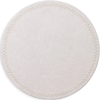 The Starry Night Placemat s/4 by Kim Seybert features a round, light beige textured design with subtle stitching and metallic trim—an easy-to-clean placemat that brings elegance to any table setting.
