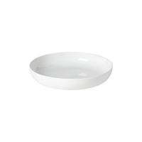 A simple, round, white porcelain bowl with a wide rim, from the Costa Nova Resonance Porcelain Dinnerware collection by Costa Nova, displayed on a white background and inspired by Carsten Gollnick’s refined design aesthetic.