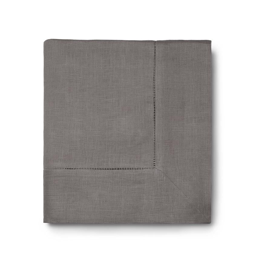 The Sferra Festival Tablecloth is a neatly folded gray fabric with a decorative hemstitch border, shown against a white background.