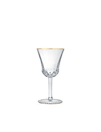 The Apollo Stemware by Saint-Louis/Hermès is a clear crystal wine glass with vertical ribbed detailing, a thin stem, and a gold rim—mouthblown, hand-cut, and shown upright on a white background.