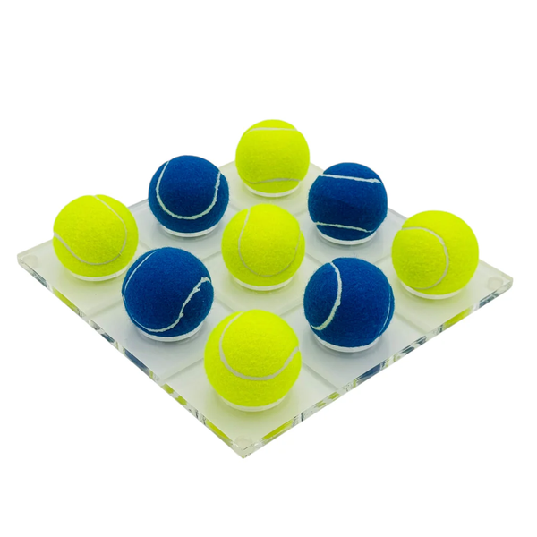 The Tennis Ball Tic Tac Toe - Blue / Yellow by Luxe Dominoes features nine blue and yellow balls arranged in a 3x3 grid on an acrylic board, making a fun tennis-themed gift or unique coffee table game.