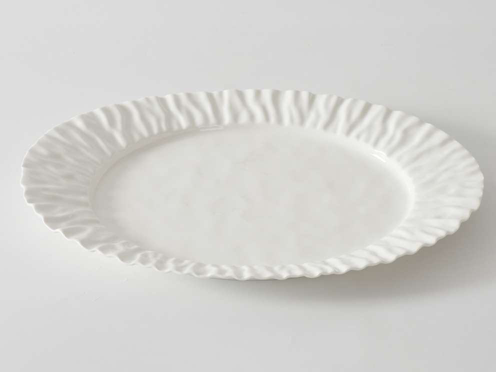 The PAMPA BAY Mascali Bianca Serving Platter is a large, white, round porcelain platter with a ruffled textured edge; it’s both elegant and microwave safe, shown here on a plain white surface.