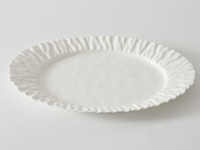The PAMPA BAY Mascali Bianca Serving Platter is a large, white, round porcelain platter with a ruffled textured edge; it’s both elegant and microwave safe, shown here on a plain white surface.