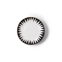 The Molecot Punk Dinnerware round white Limoges porcelain plate features a black and white geometric starburst rim and a thin gold edge, shown from above on a plain white background.