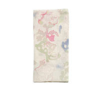The Giverny Napkin Mint and Multi by Kim Seybert features a folded, light-colored linen with a subtle floral pattern in pink, green, and blue on a white background.