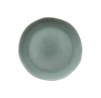 The Maguelone Cachemire Dinnerware plate by Jars - Rosenthal is a round, matte, light gray-green handmade piece with a slightly uneven, organic shape, shown from above on a white background.