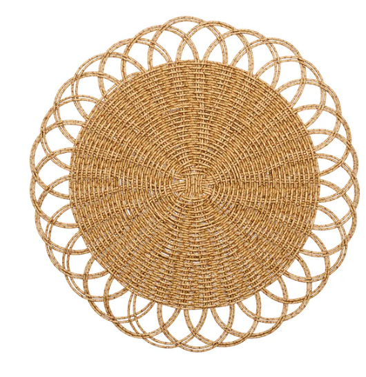 The Alfresco Placemat Set of 4 by Kim Seybert features round, handwoven placemats with an intricate pattern and scalloped edges in natural light brown—ideal for outdoor dining.