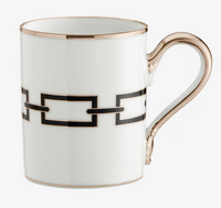 Introducing the Catene Nero Dinnerware mug by Ginori 1735—a white porcelain mug with a gold handle and rim, adorned with a striking black geometric linked-square pattern encircling its surface.