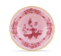 The Oriente Italiano Porpora plate by Ginori 1735 is a pink Italian porcelain piece with gold trim, showcasing intricate dark pink floral and oriental patterns inspired by classic Ginori elegance.