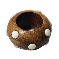 The Candy Dots Napkin Ring Set of 4 by Von Gern Home features round, brown wooden rings with hollow centers, decorated with evenly spaced white dots—part of the brand's playful collection.