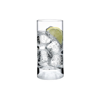 A clear high ball glass from the Nude Glassware Club Drinkware Set of 4, filled with sparkling water, ice cubes, and a slice of lime, highlights modern industrial style against a white background.