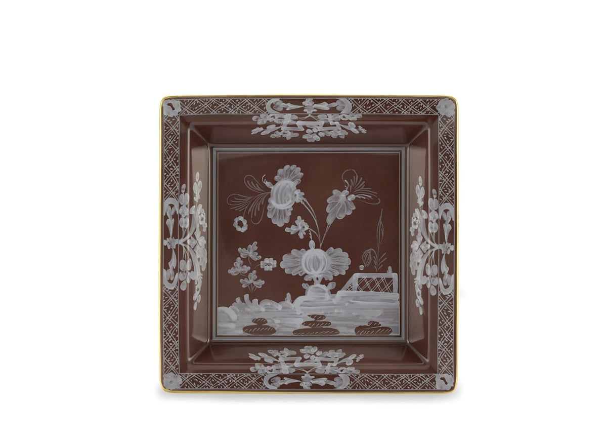 The Oriente Italiano Castagna square brown porcelain plate by Ginori 1735 features a white floral and geometric border, gold trim, and stylized central flowers with a fence motif. Made in Italy.