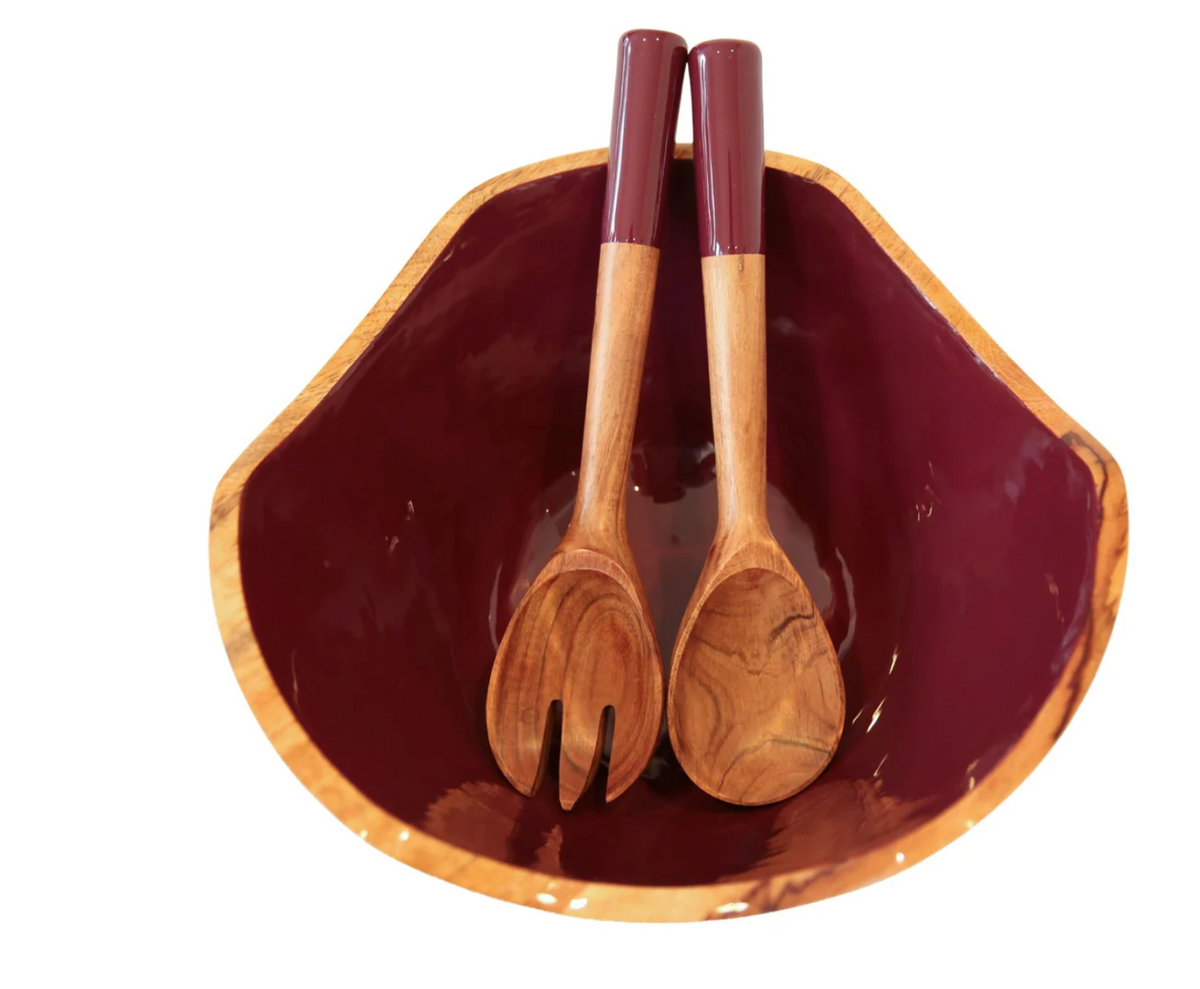 The Indy Home Montauk Serving Bowl With Servers features a mango wood bowl with a glossy maroon interior, plus handmade matching wooden salad fork and spoon with maroon handles, shown from above on a white background.